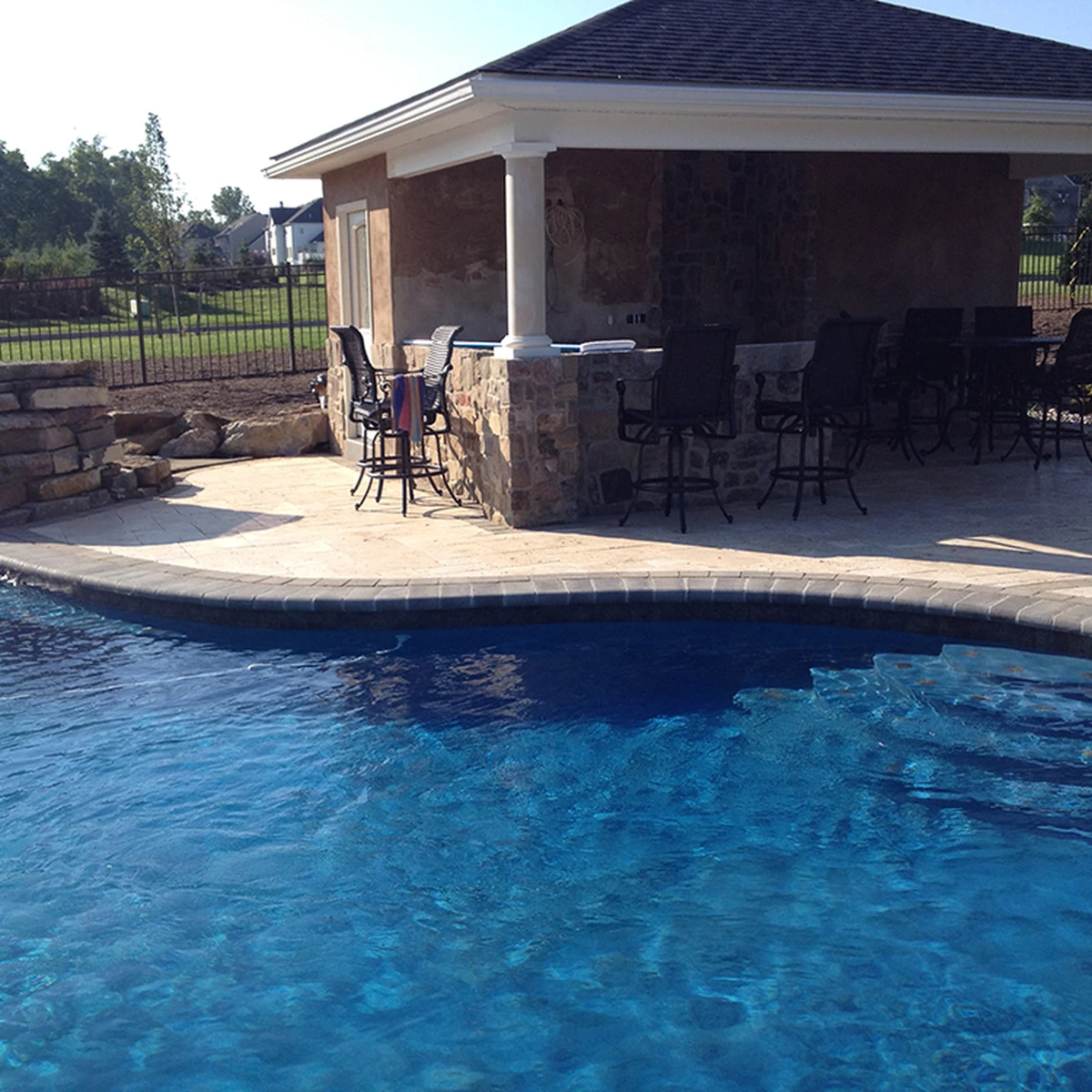 Great Valley Landscape & Pool cabana with stone bar beside a freeform inground pool